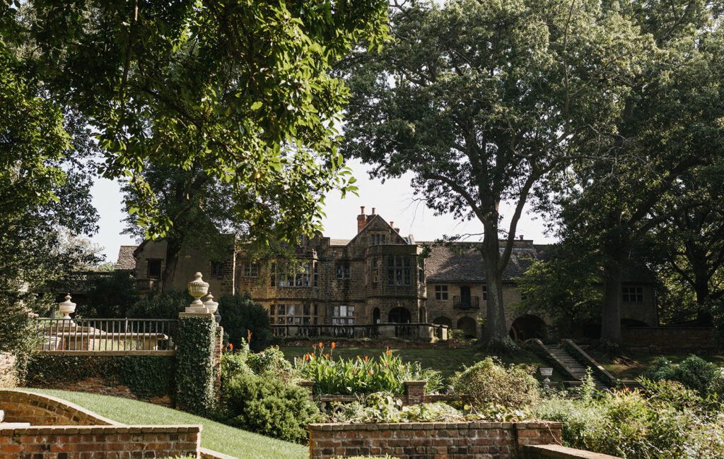 Exterior view of the historic Virginia House wedding venue in Richmond, Virginia, showcasing stone architecture and manicured gardens.