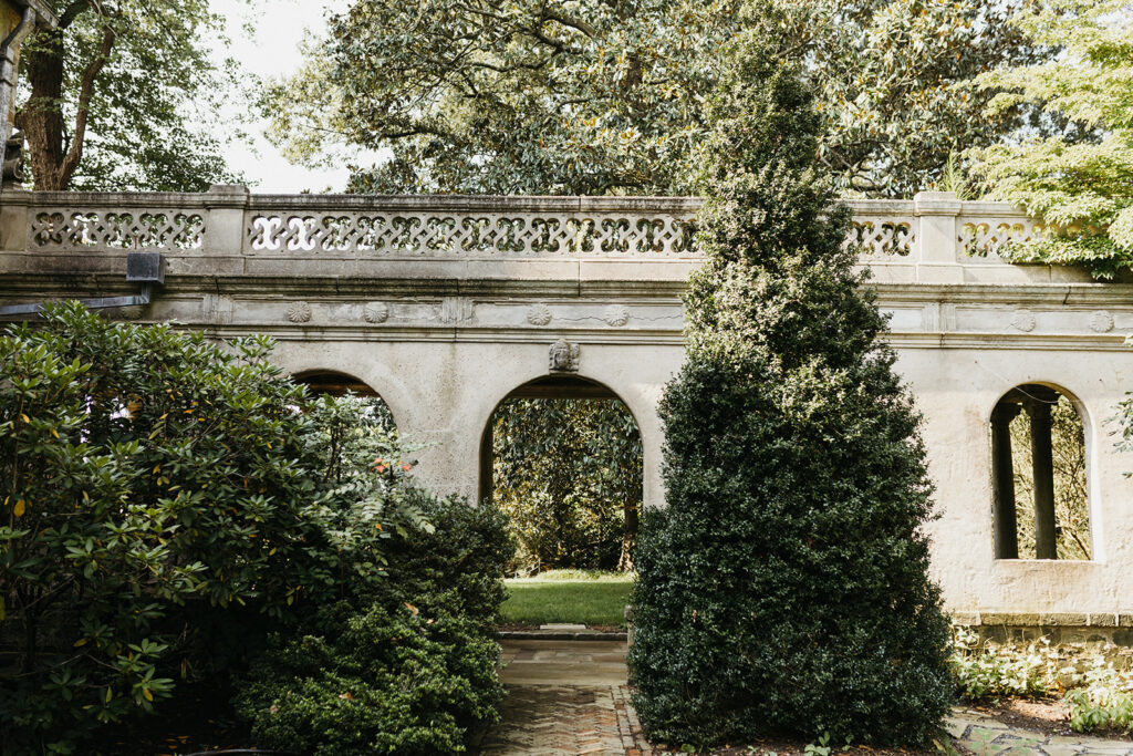 Exterior view of the historic Virginia House wedding venue in Richmond, Virginia, showcasing stone architecture and manicured gardens.