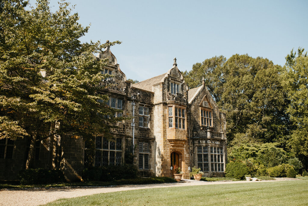 Exterior view of the historic Virginia House wedding venue in Richmond, Virginia, showcasing stone architecture and manicured gardens.