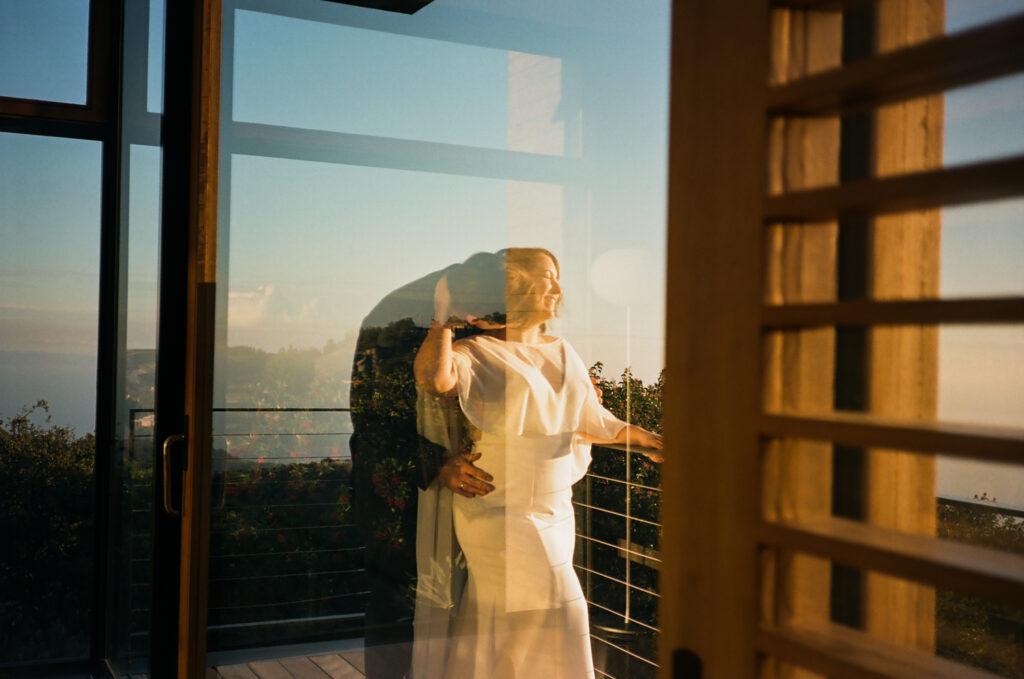 Bride and groom on balcony at the Saddle Peak House in Topanga Canyon during sunset.