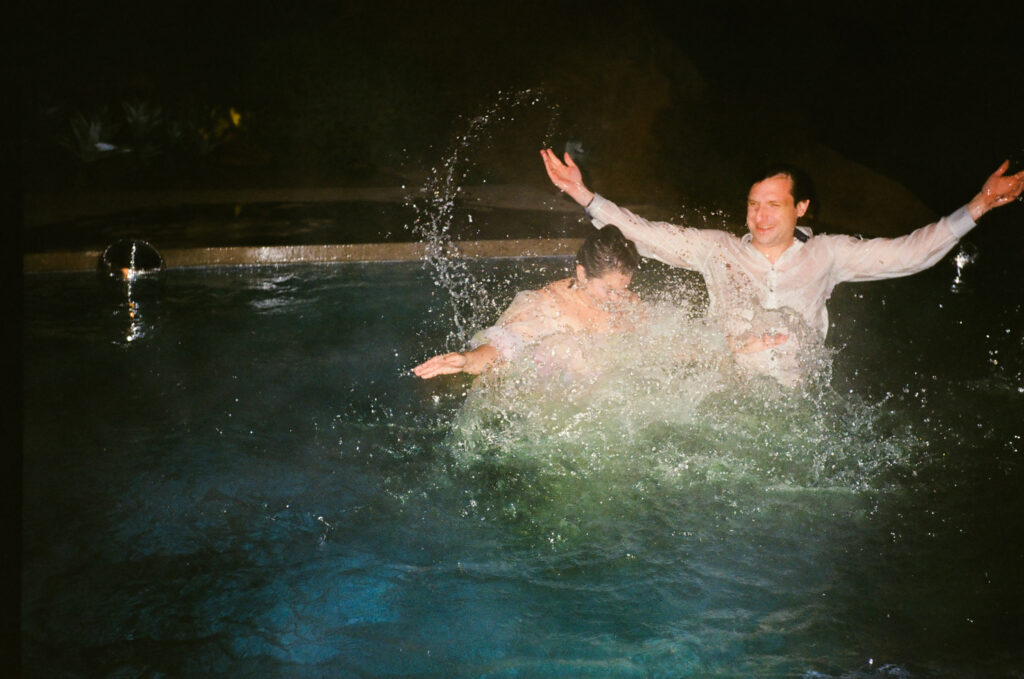 Couple splashing in the pool in Topanga Canyon Malibu Destination Wedding
