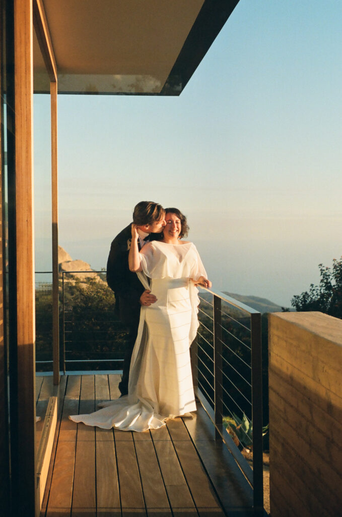 Bride and groom on balcony at the Saddle Peak House in Topanga Canyon during sunset.