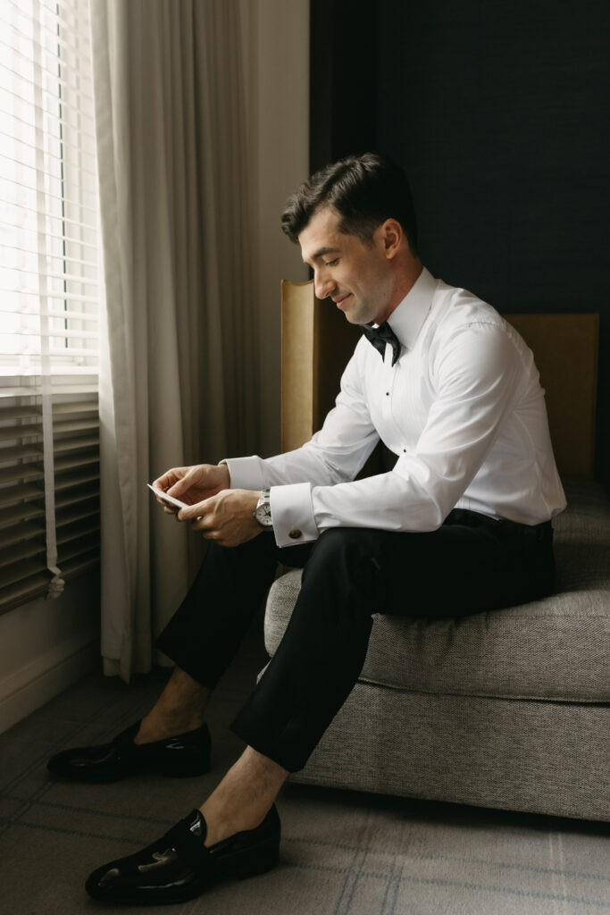 Groom reading a letter from his bride in the groom's getting ready suite at the Hyatt Hotel in Washington DC.