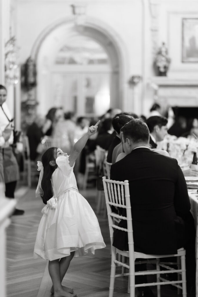 Flower girl pointing at the bride and groom as they enter their reception at their Larz Anderson House DC Wedding