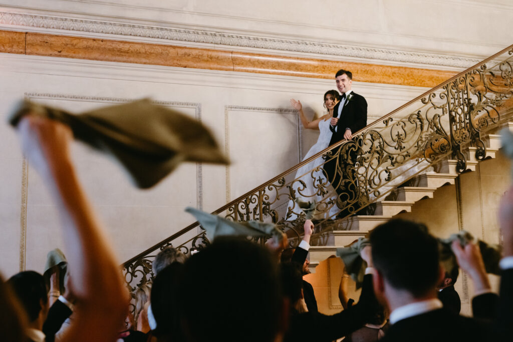 Bride and groom waving at guests entering their reception at Larz Anderson House DC Wedding