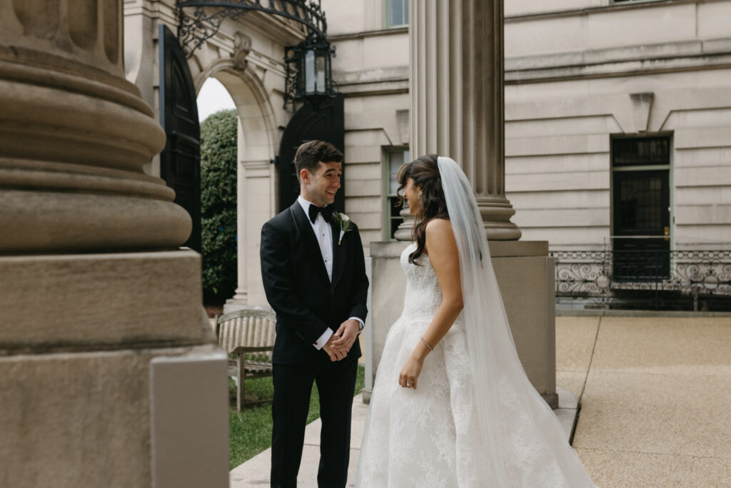 Groom reacting happy to seeing his bride during their first look at the Larz Anderson House. 
