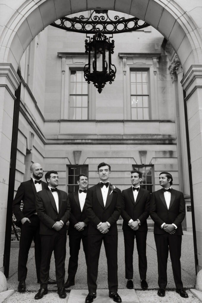 Groom and Groomsmen in formal black tie attire posing in front of the Larz Anderson House