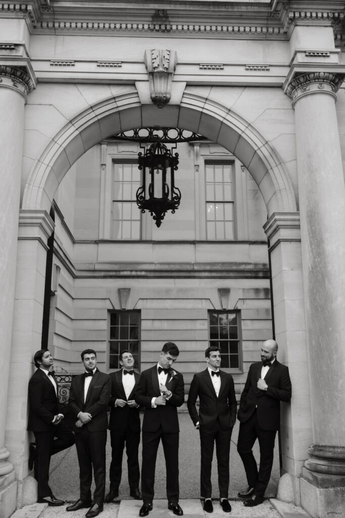 Groom and Groomsmen in formal black tie attire posing in front of the Larz Anderson House