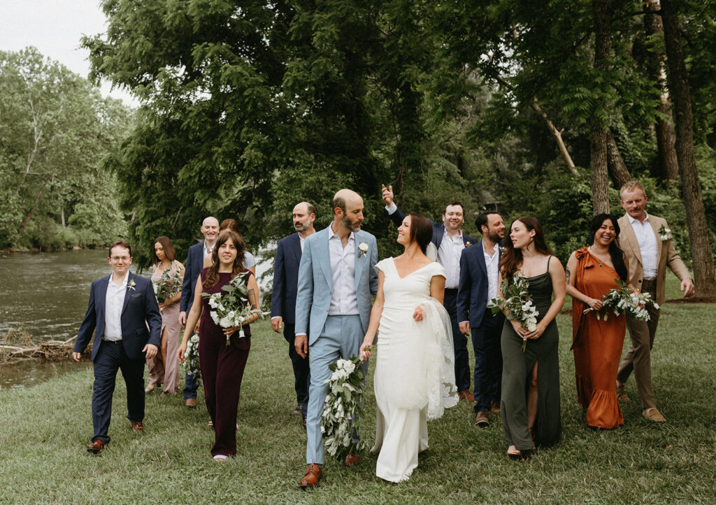 Abingdon Virginia summer wedding — bride and groom surrounded by friends walking along the river.