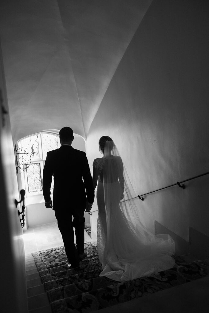Bride and groom walking down stairs holding hands at Branch Museum 