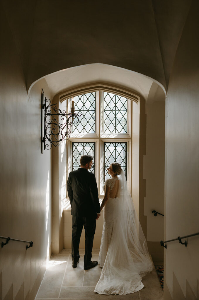 Bride and Groom holding hands in front of a window at Branch Museum in Richmond, Virginia.