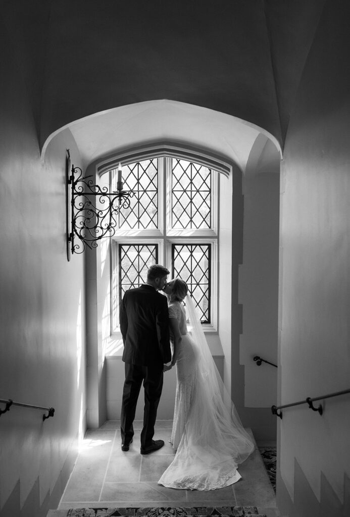 Bride and Groom kissing in front of a window at Branch Museum Richmond venue