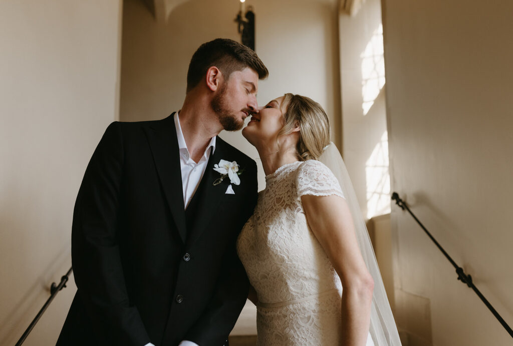 Bride and Groom kissing in front of a window at Branch Museum in Richmond, Virginia.