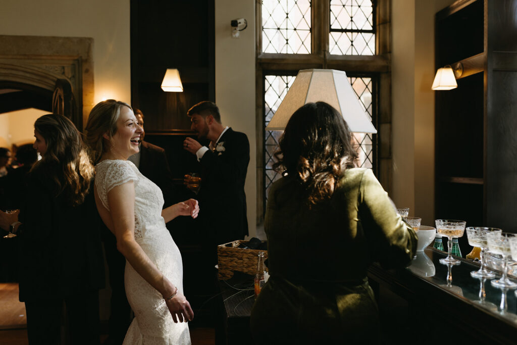 Guests laughing with bride at cocktail hour at Branch museum in Richmond, Virginia.