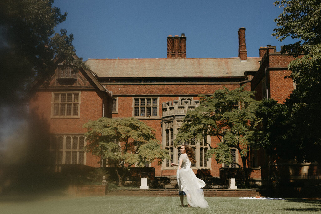 Portrait of woman in vintage dress and robe running in garden at the Branch Museum in Richmond, Virginia. 
