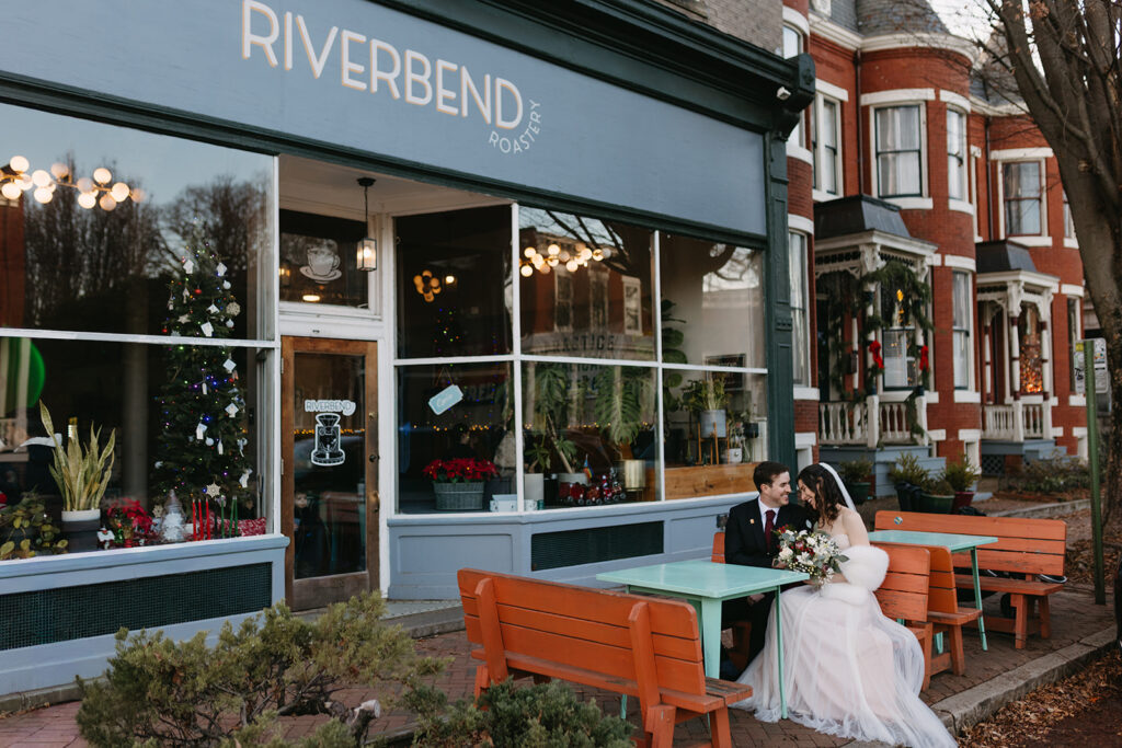 Bride and Groom sitting on bench in front of Riverbend Roastery in the Church Hill neighborhood of Richmond, Virginia.