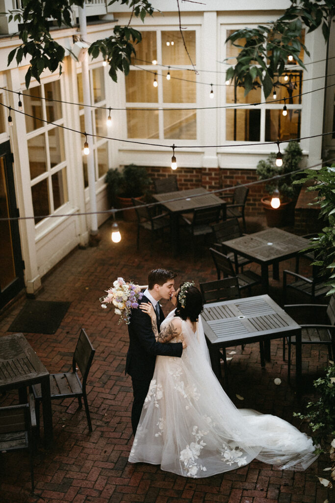 Bride and groom dancing in the courtyard at the Linden Row in Richmond, Virginia illuminated by string lights. 