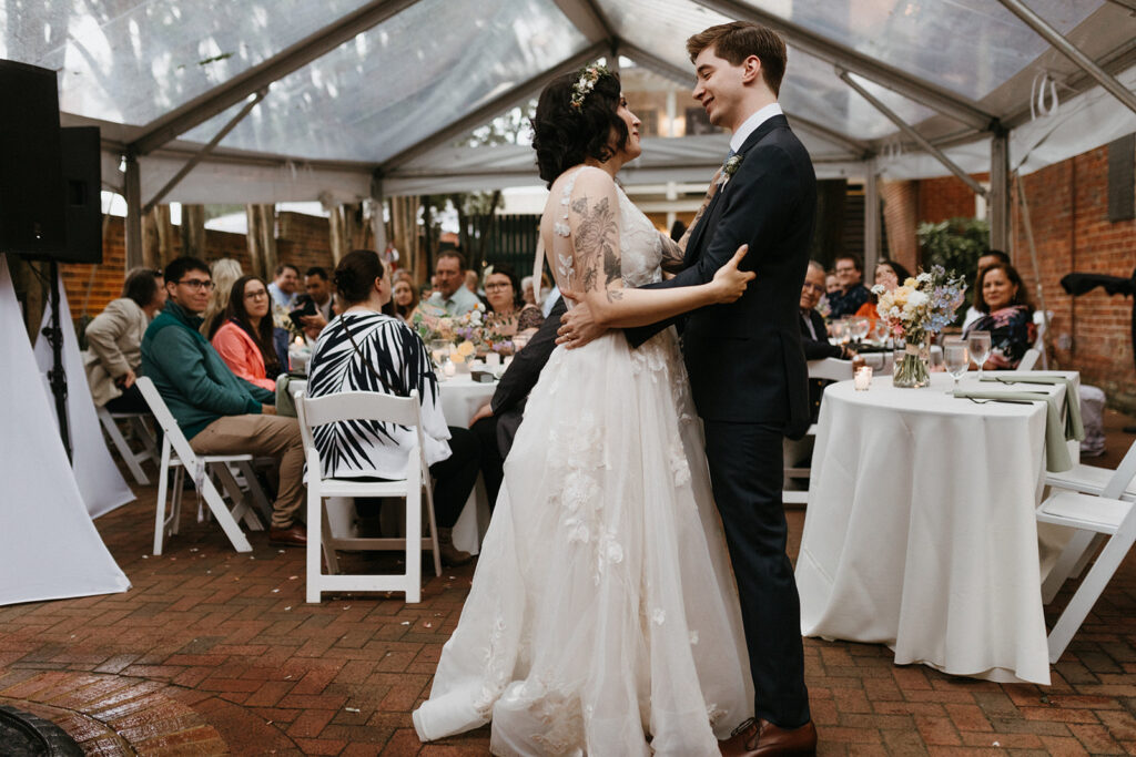 Bride and groom sharing their first dance in front of guests at the Linden Row in Richmond Virginia Historic Wedding Venue.
