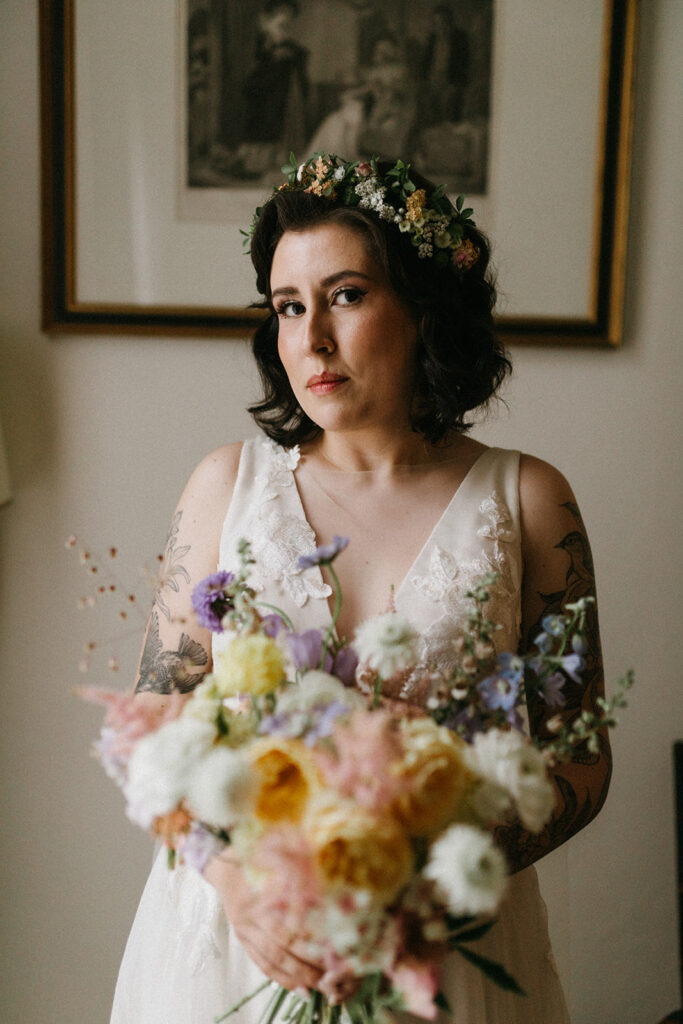 Bridal portrait of a bride in gown from Blue Sage Bridal and her bouquet from Hazel Witch Farm at Linden Row on her wedding day. 