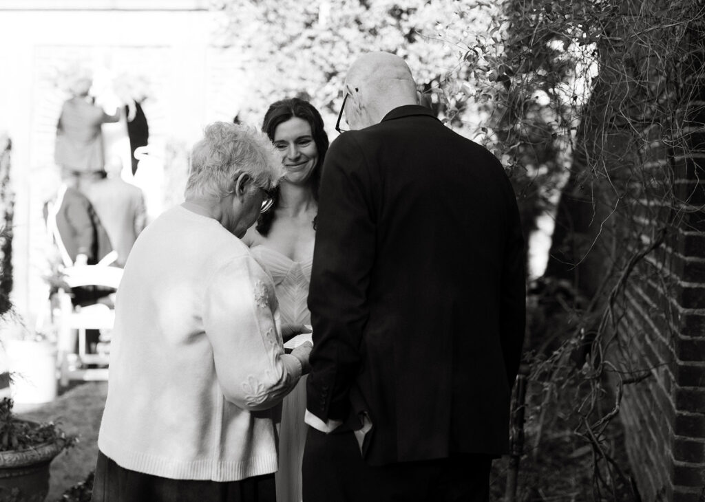 Bride sharing letters and tears with her parents at the Poe Museum on her wedding day.