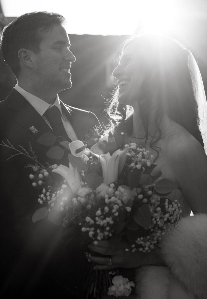 Bride and Groom laughing together with the sunset behind them at their Richmond winter micro wedding.