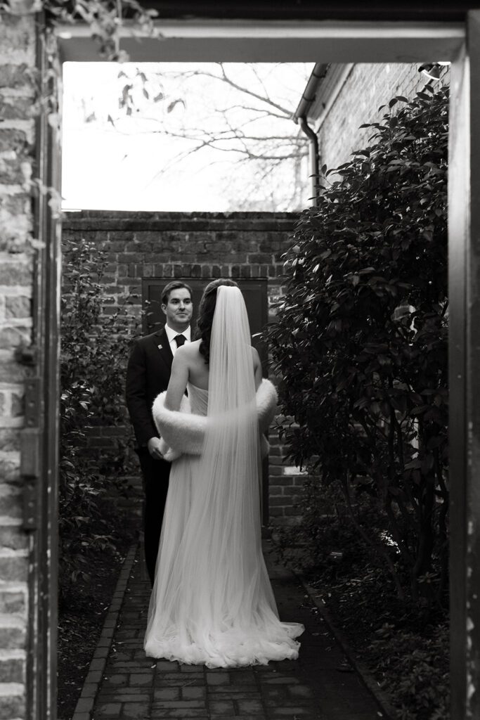 Portrait of bride and groom walking out of the Poe Museum on their wedding day.