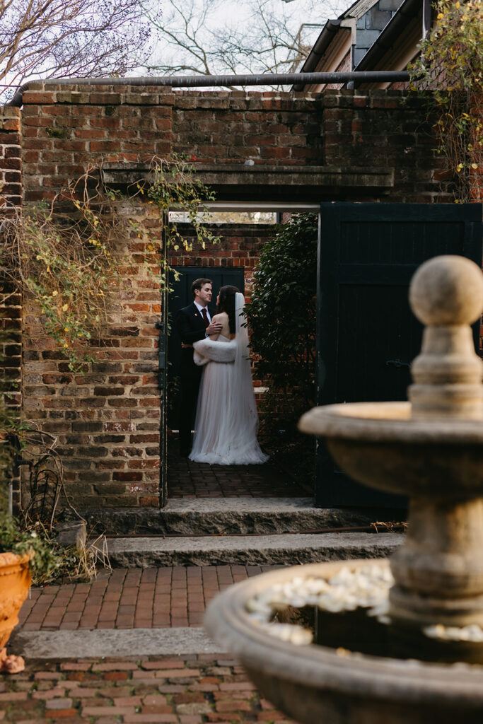 Portrait of bride and groom walking out of the Poe Museum on their wedding day.