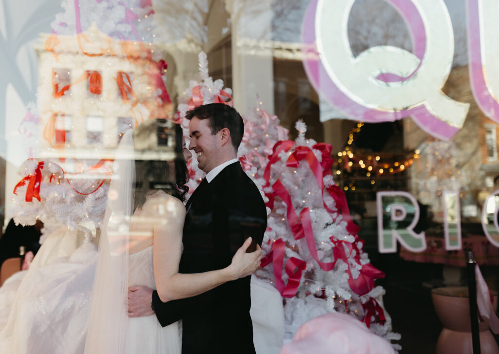 Portrait of bride and groom taken through the window of the Quirk Hotel.
