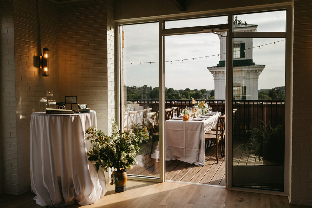 Reception room at Summers Roof and Cellar, decorated with summer florals and family-style tables.