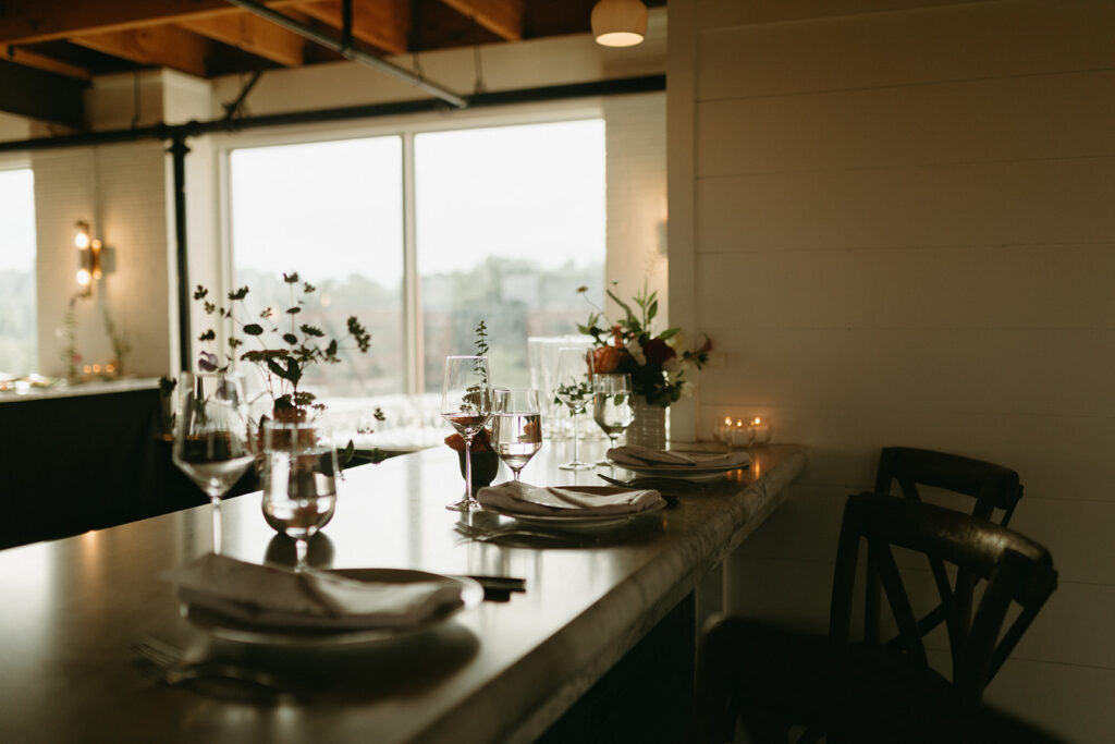 Reception room at Summers Roof and Cellar, decorated with summer florals and family-style tables.