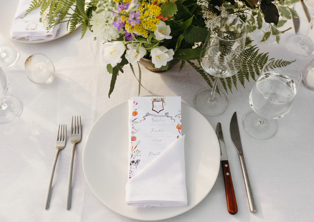 Reception room at Summers Roof and Cellar, decorated with summer florals and family-style tables.