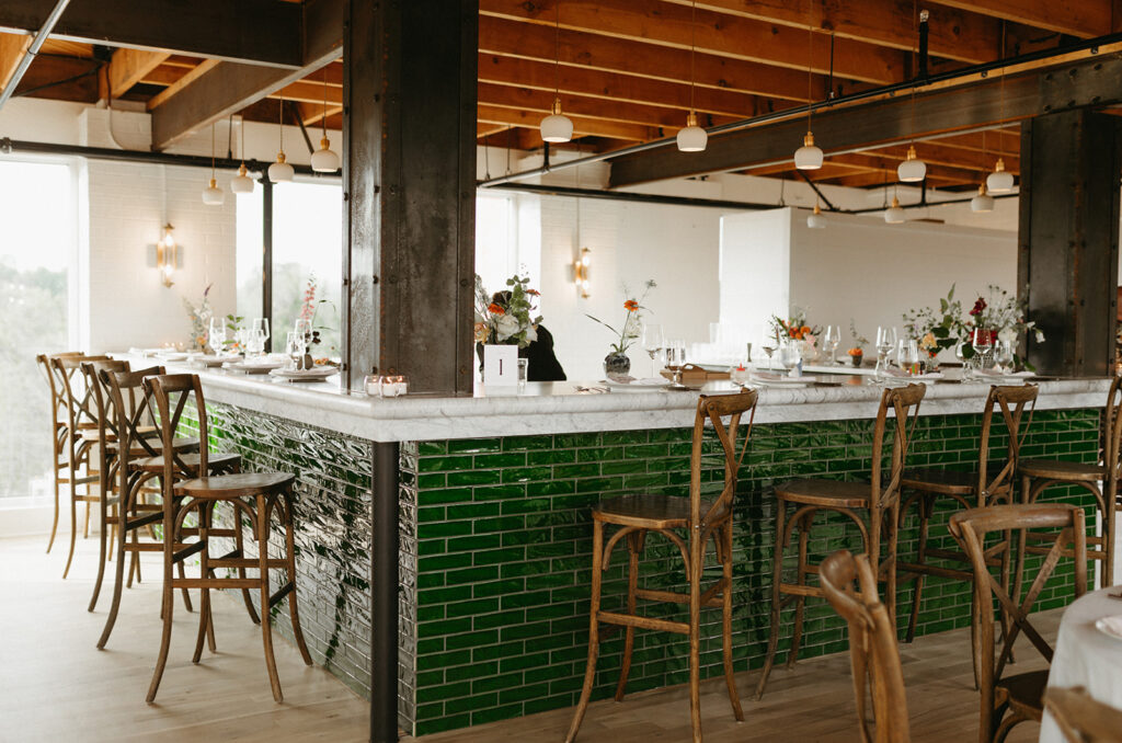 Reception room at Summers Roof and Cellar, decorated with summer florals and family-style tables.