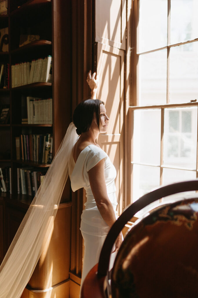 Abingdon Virginia summer wedding — bride in soft natural light by a window in the library at the Martha Washington Inn, calm and radiant.